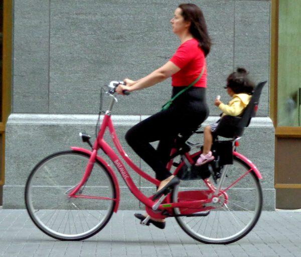 Frau fährt Fahrrad mit Kind