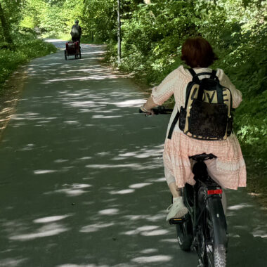 Zwei Radfahrer fahren von der Kamera weg auf dem Radweg im Friedenstal